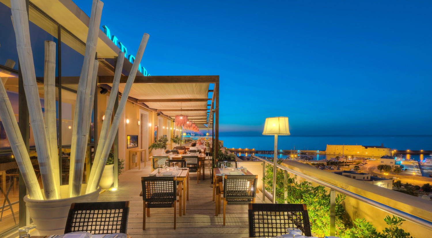 Rooftop restaurant terrace with harbour view at dusk