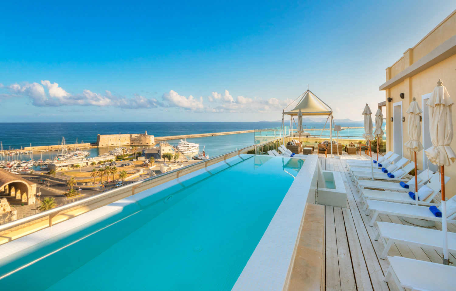 Rooftop pool overlooking Heraklion at golden hour